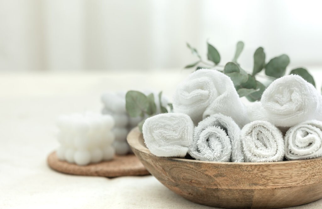 spa composition with white towels in a wooden plate.